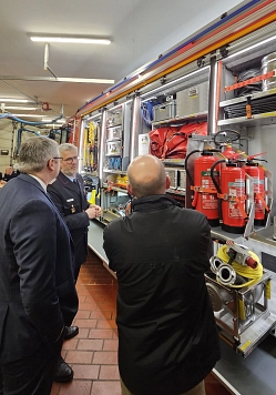 Drei Männer stehen vor einem geöffneten Feuerwehrwagen und schauen sich das Material im Wagen an. © Landkreis Rotenburg (Wümme)